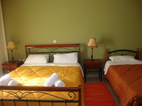 1 dormitorio con 2 camas y 2 mesitas de noche con lámparas en Kafiona Guesthouse, en Pyrgos Dirou