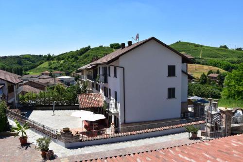 a white house with a roof with a patio at B&B La Dolce Vita in Priocca
