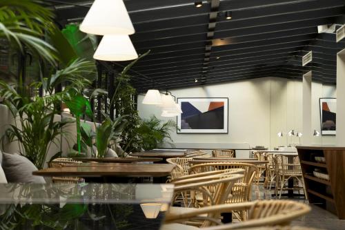 a restaurant with tables and chairs and potted plants at ICON Embassy in Madrid
