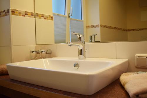 a white sink in a bathroom with a mirror at Haus Partale in Oberstdorf