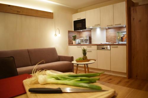 a kitchen with a table with green onions on a cutting board at Haus Partale in Oberstdorf