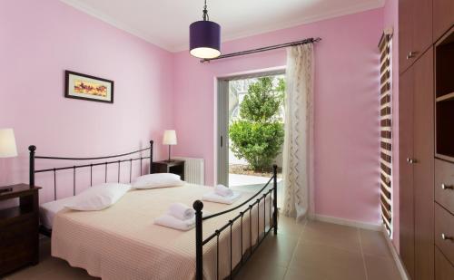 a bedroom with a bed and a window at Villa Soumela in Nikiana