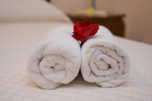 a pair of towels with a rose on a bed at Kefalos Quiet Apartment In Argostoli in Argostoli