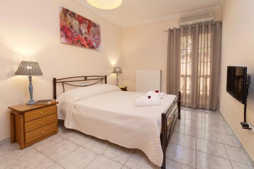 a bedroom with a bed and a dresser and a television at Kefalos Quiet Apartment In Argostoli in Argostoli