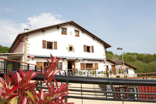 une maison blanche avec une clôture noire devant elle dans l'établissement Camping Igara de San Sebastian, à Saint-Sébastien