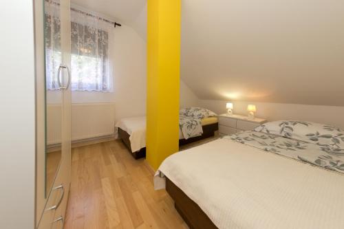 1 dormitorio con 2 camas y pared amarilla en Stay In Touch, en Gospić