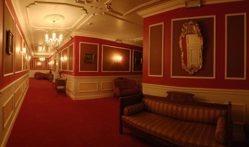 a living room with a couch and a mirror at Hotel Na Błoniach in Bielsko-Biała