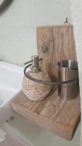 ein Holzregal mit einem Seil und einer Thermoskanne darauf in der Unterkunft Amore a prima vista b&b in Campiglia Marittima