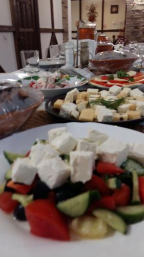 a plate of food with cheese and vegetables on a table at Karpatska Mria in Yaremche