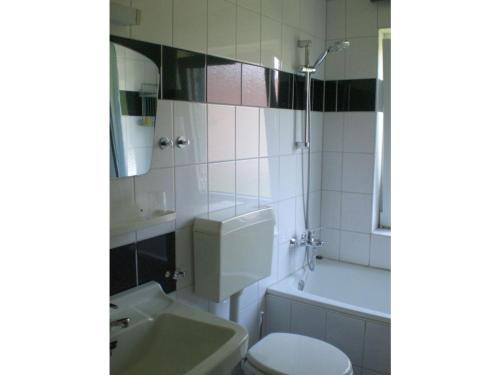 a bathroom with a sink and a toilet and a tub at Ferienwohnung Gätcke in Hemmoor