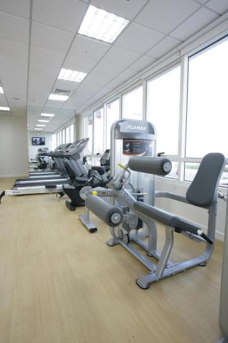 a gym with a row of treadms and cardio machines at Ramada by Wyndham Beach Hotel Ajman in Ajman 