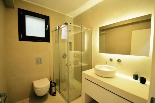 a bathroom with a sink and a shower and a toilet at Asaya Hills Villas in Parga