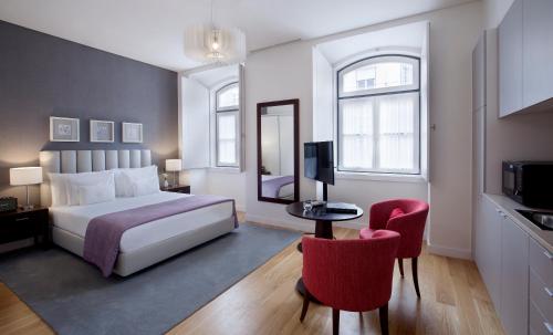 Grape Harbor Prata Apartments في لشبونة: غرفة بالفندق سرير وكرسيين حمر