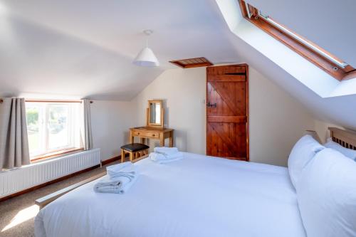 1 dormitorio con 2 camas y ventana en 3 Beach Cottages - Aldeburgh Coastal Cottages, en Thorpeness