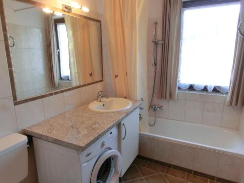 a bathroom with a sink and a washing machine at Appartement Inge in Kaprun