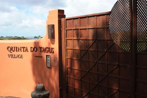 a gate to a building with a sign on it at Quinta Tagus in Costa da Caparica