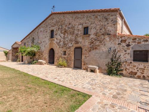 een oud stenen huis met een geplaveide oprit bij Belvilla by OYO Pahissa Can Abres in Cassà de la Selva