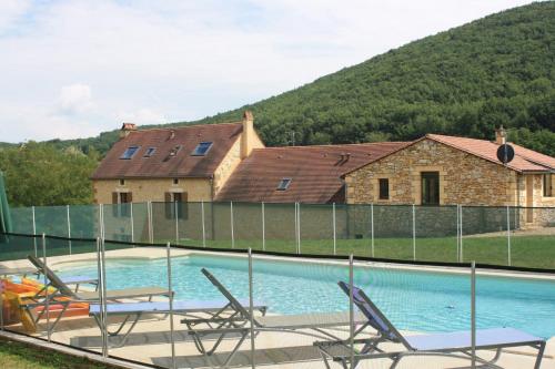 a swimming pool with chairs in front of a house at Cottage de La Mothe in Marnac