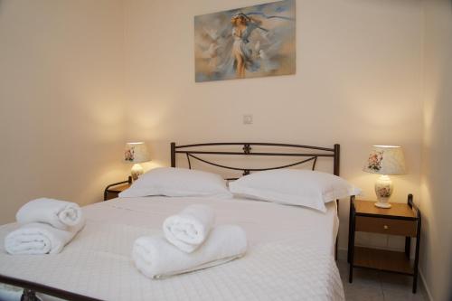 una camera da letto con un letto bianco e asciugamani di "Hermes" central apartment ad Argostoli