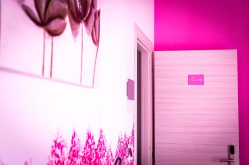 a white door in a room with pink lighting at Colors B&B in Palermo