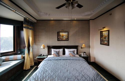 a bedroom with a bed and a ceiling fan at Hotel Diplomat Residency in New Delhi