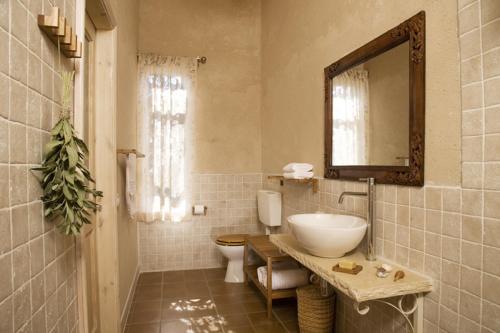 a bathroom with a sink and a toilet and a mirror at Smadar-Inn in Zikhron Ya‘aqov