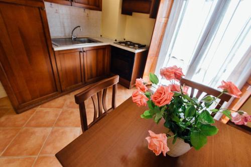 a kitchen with a table with a vase of flowers on it at Borgo Venecca in Fonteblanda
