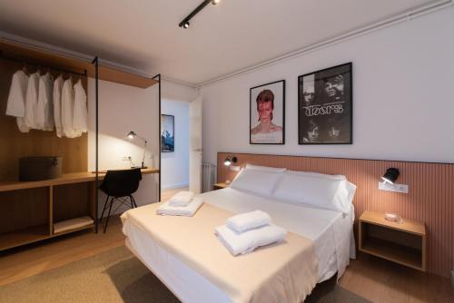 Petit Luxe l'Àtic في تيراسا: غرفة فندق عليها سرير وفوط