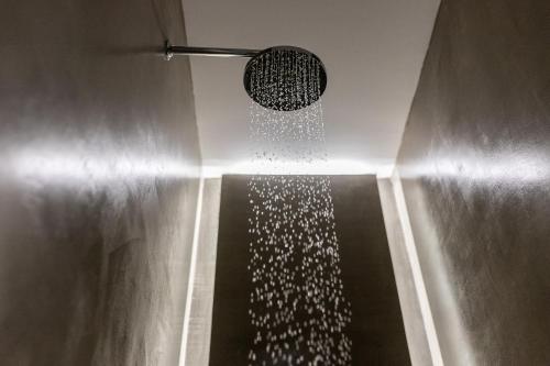 a shower with a shower head in a bathroom at Aegean Gem in Kamari