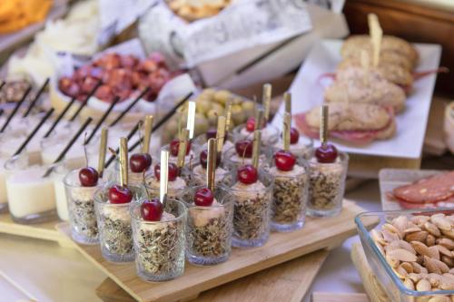 a table topped with jars of food with cherries and cookies at The Level at Meliá Villaitana in Benidorm