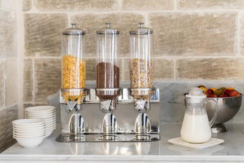 a kitchen counter with three containers of cereal and milk at Cesca's Boutique Hotel in Xlendi