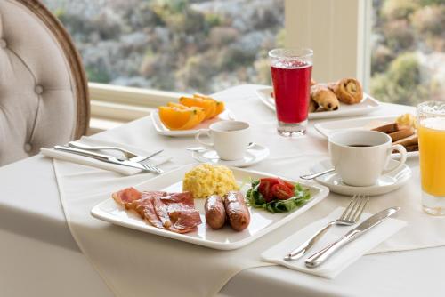 a table with two plates of breakfast foods and drinks at Cesca's Boutique Hotel in Xlendi