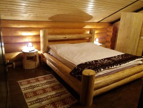1 dormitorio con 1 cama en una cabaña de madera en Casa Eco Dorna 1 en Vatra Dornei