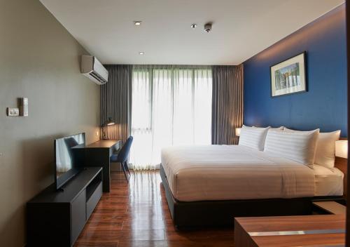 a hotel room with a bed and a television at Amp Am House Bangkok Hotel in Bangkok