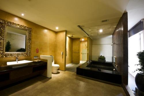a bathroom with a sink and a toilet and a mirror at Belle Song Motel in Shulin