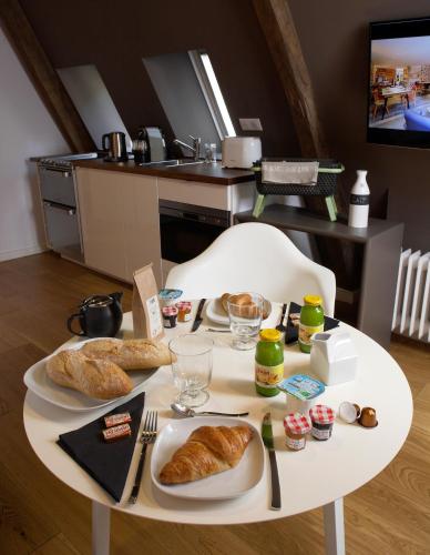 a white table with croissants on it in a kitchen at Les Maisons du Pont - Charme & Caractère in Aubusson
