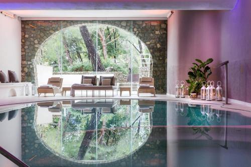 a room with a pool with chairs and a table at Hotel Piccolo Sant'Andrea in Praiano