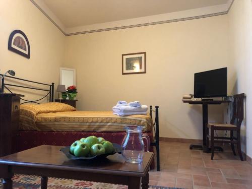 モンテファルコにあるAppartamenti San Roccoのベッド1台、テーブル(フルーツボウル付)が備わる客室です。
