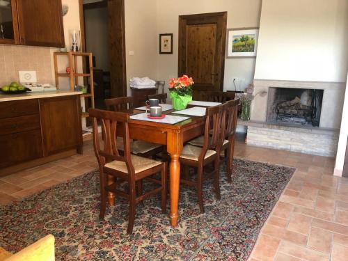 a kitchen with a wooden table with chairs and a fireplace at Appartamenti San Rocco in Montefalco