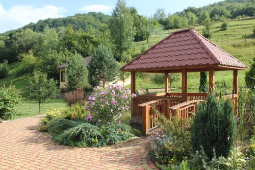 a wooden gazebo in the middle of a garden at Svit Sontsya in Turʼya Polyana