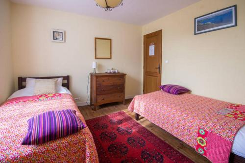 a bedroom with two beds and a dresser at Val d'Arguenon in Jugon Les Lacs