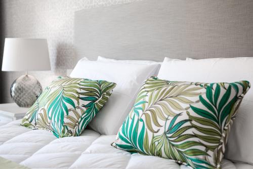 a white bed with two pillows on top of it at Cesca's Boutique Hotel in Xlendi