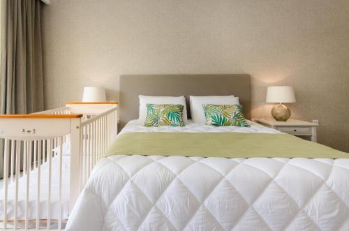 a white crib with two pillows in a bedroom at Cesca's Boutique Hotel in Xlendi
