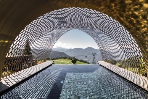 a view of a swimming pool through an archway at Gloriette Guesthouse Hotel & Restaurant in Soprabolzano