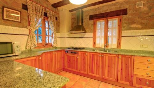 a kitchen with wooden cabinets and a counter top at Mas Del Cigarrer Allotjament Rural in Horta de San Joan