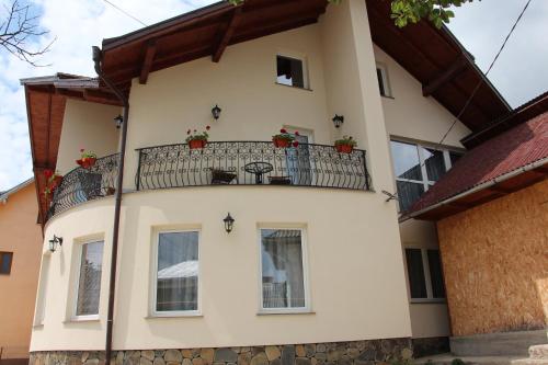 a building with a balcony with flowers on it at Popasul Călătorului in Moisei