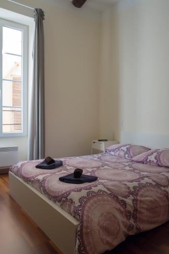 une chambre avec un lit avec deux chapeaux dessus dans l'établissement Magnifiques Appartements au coeur du Vieux Nice, à Nice