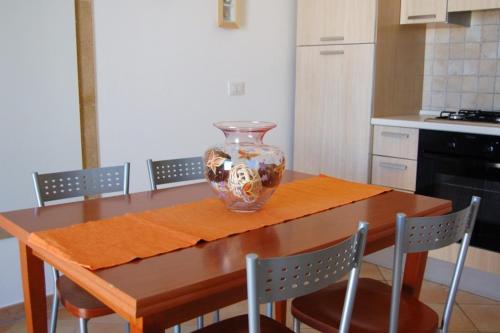 un vaso seduto sopra un tavolo di legno in cucina di Il Corbezzolo a Santa Cesarea Terme