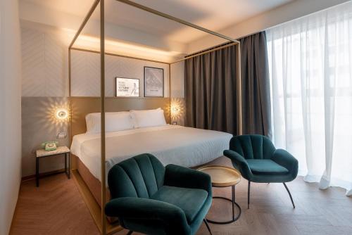 a hotel room with a bed and two chairs at The Box Riccione - Adults Only in Riccione