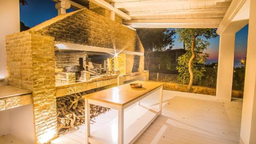 an outdoor kitchen with a stone fireplace on a patio at Icons Sea of Crete in Malia